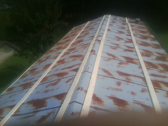 Rusted metal roof panels with new wood purlins before replacement — Storm Damage Roof Repair in Nicholson by Roofing Brothers