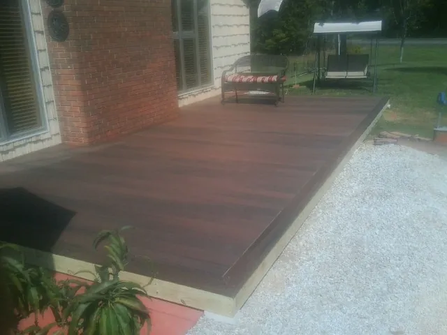 Freshly stained wood deck built against a brick home in Nicholson
