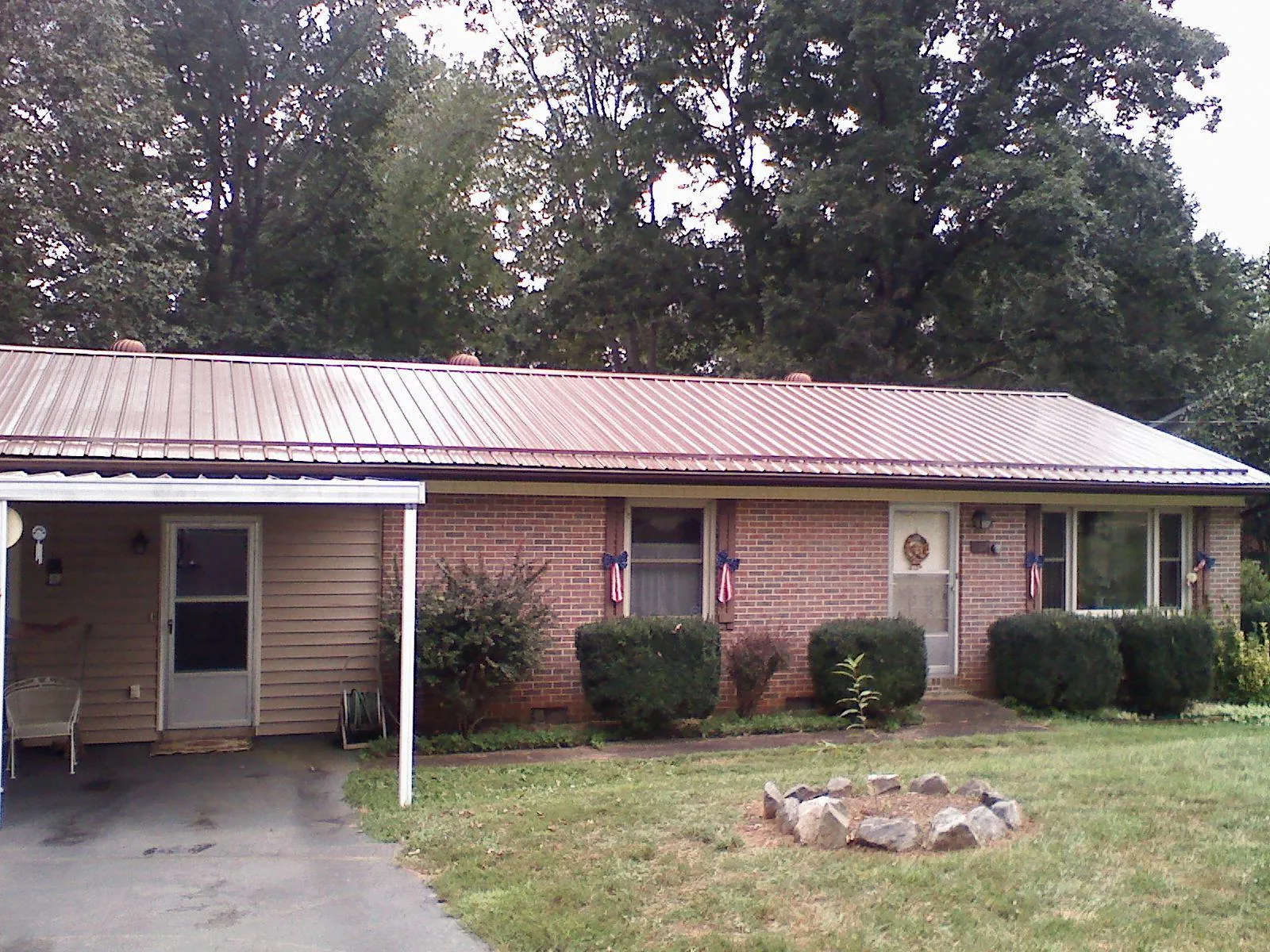Bronze metal roof and carport on a brick ranch home — Roof Repair work by our crew in Nicholson